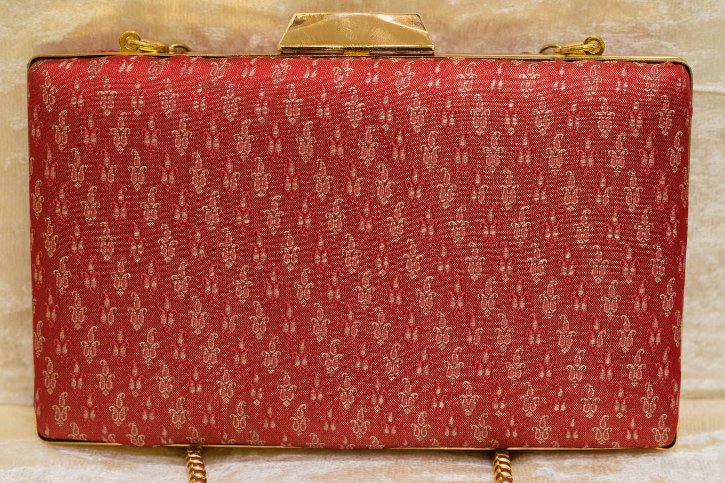 Red Banarasi brocade clutch bag with gold traditional pattern and chain strap, handmade design.