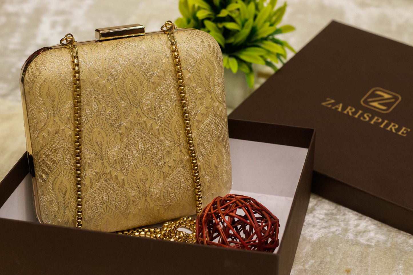 Beige Banarasi brocade clutch bag with gold chain, traditional handmade design in gift box.
