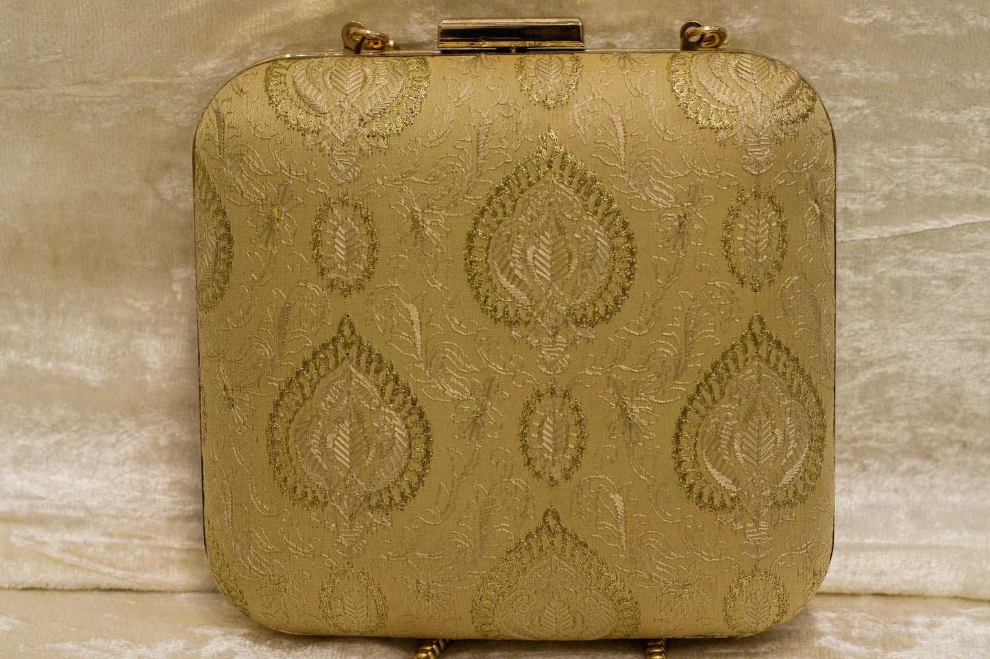 Gold Banarasi brocade clutch bag with traditional handmade chikankari embroidery and metal clasp closure.