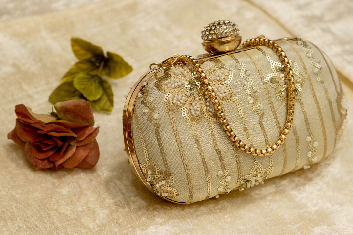 Sage green Banarasi brocade clutch bag with gold embroidery, traditional handmade design, and decorative clasp with chain.