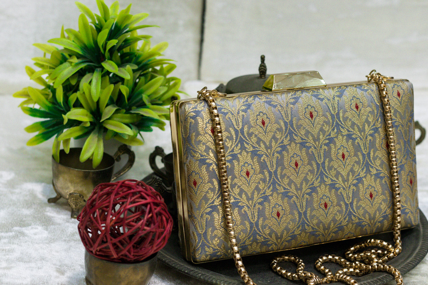 Steel blue Banarasi brocade clutch bag with intricate traditional floral patterns and gold chain strap, handmade design.