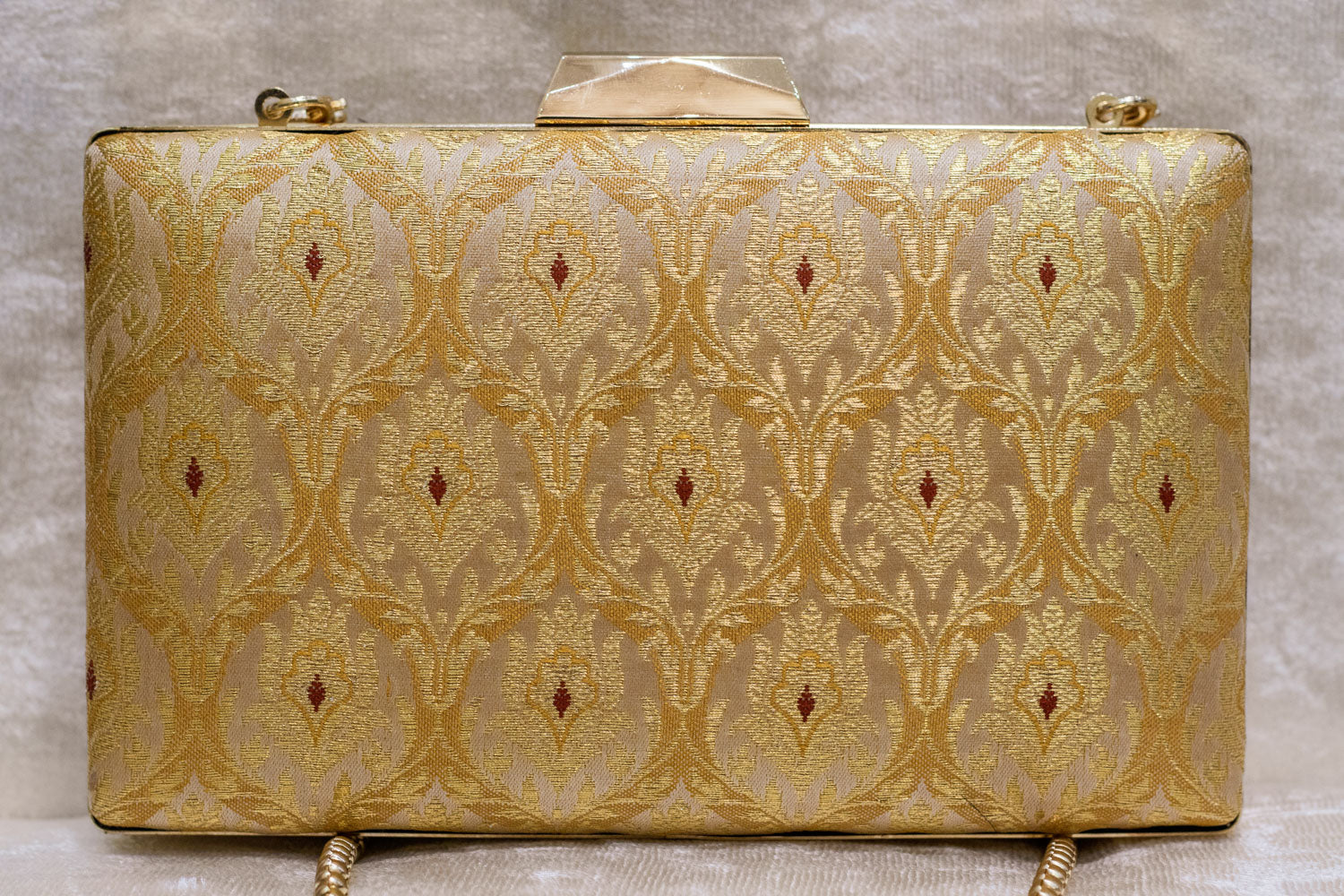Golden Banarasi brocade clutch bag with traditional floral motifs and top handle, handmade design.