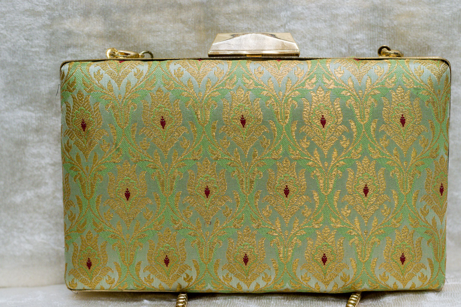 Aqua green brocade Banarasi clutch bag with traditional gold floral motifs and a handmade clasp closure.