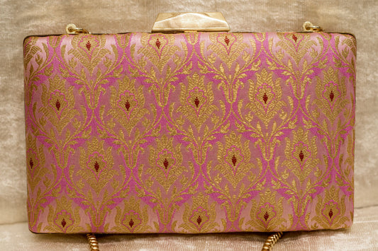 Pink Banarasi brocade clutch bag with traditional handmade gold patterns and a gold chain strap.