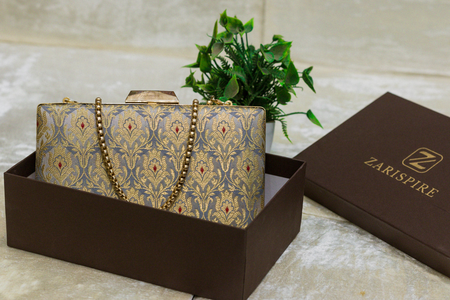 Steel blue Banarasi brocade clutch bag with traditional intricate gold embroidery, handmade design with chain strap.