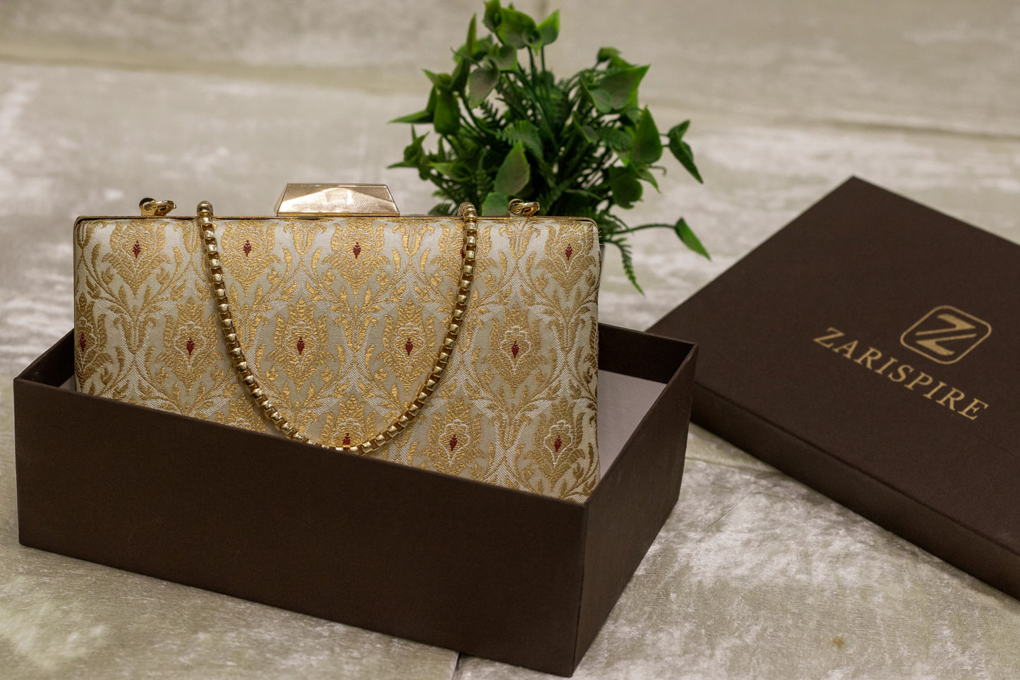 Ivory Banarasi brocade clutch bag with gold traditional pattern and chain strap, handmade design.