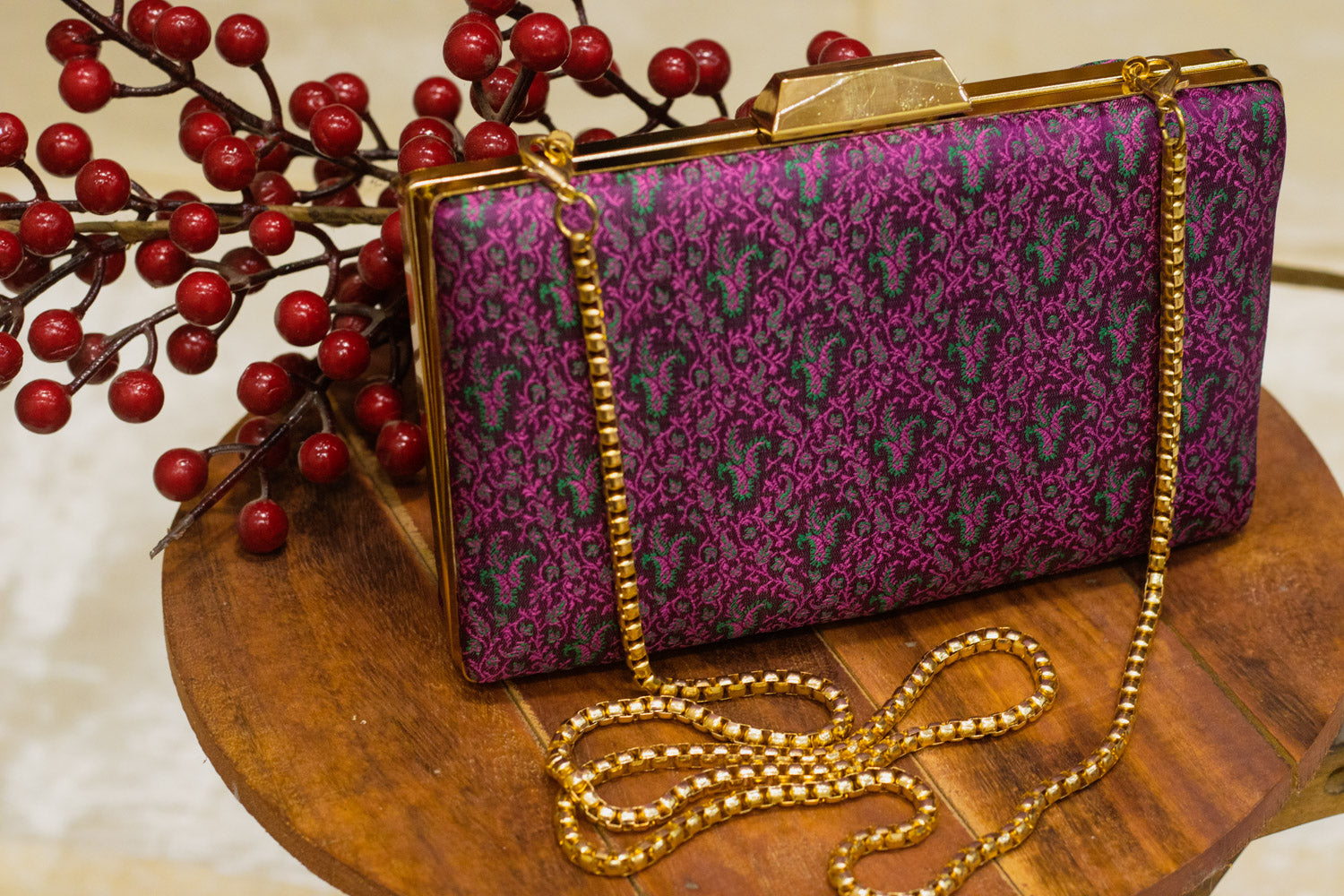 Burgundy Banarasi brocade clutch bag with gold-tone frame and chain, traditional handmade clutches.