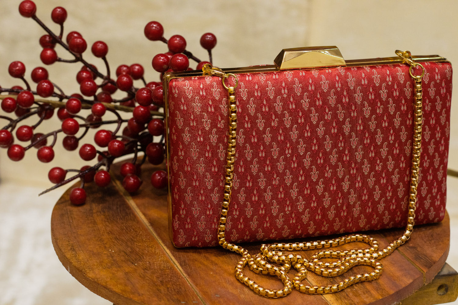 Red Banarasi brocade clutch bag with traditional gold patterns, handmade with a gold chain strap.