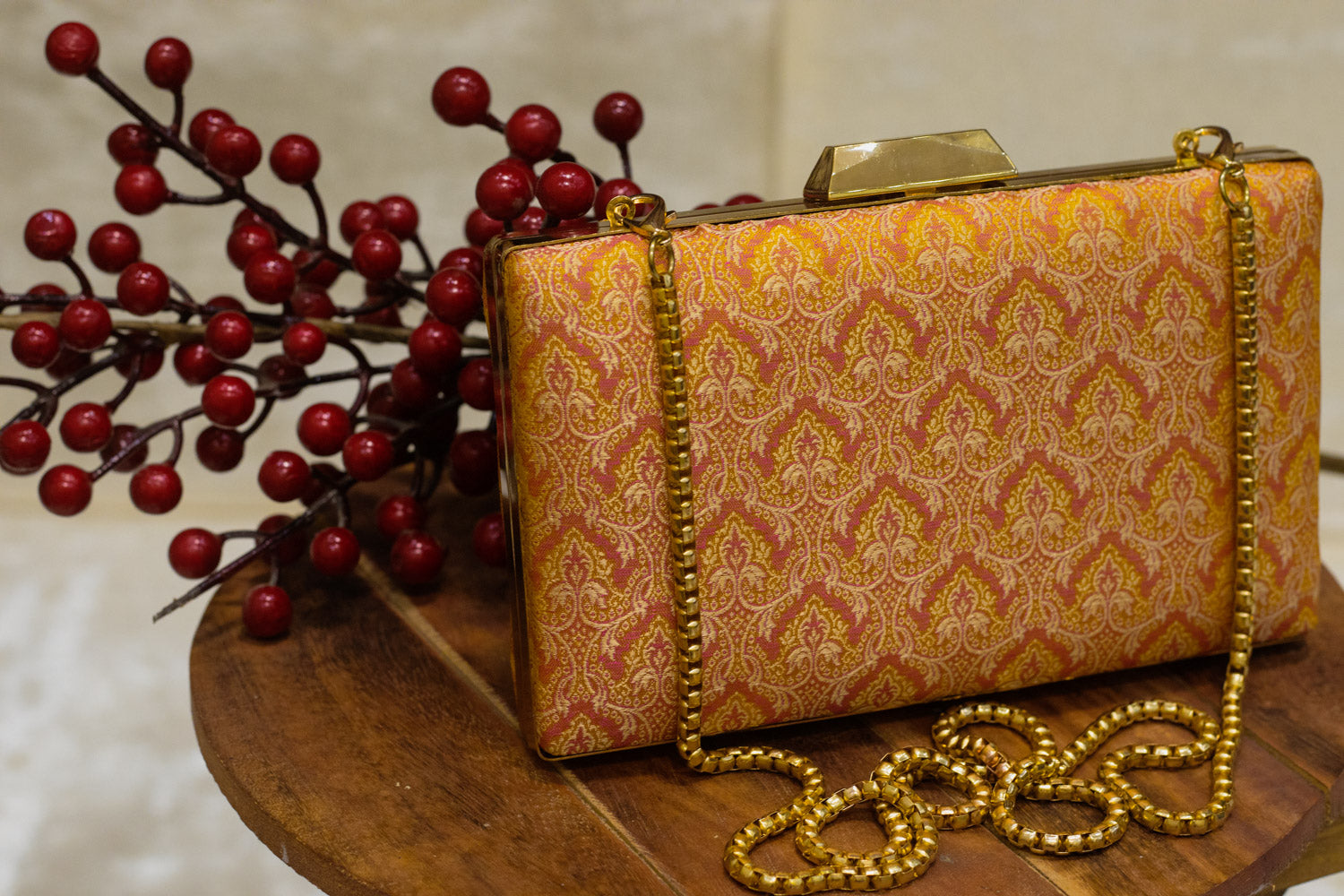Yellow Banarasi brocade clutch bag with gold-tone chain, traditional handmade design.