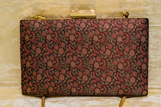 Wine-colored Banarasi brocade clutch bag with intricate traditional floral patterns and gold chain, handmade design.