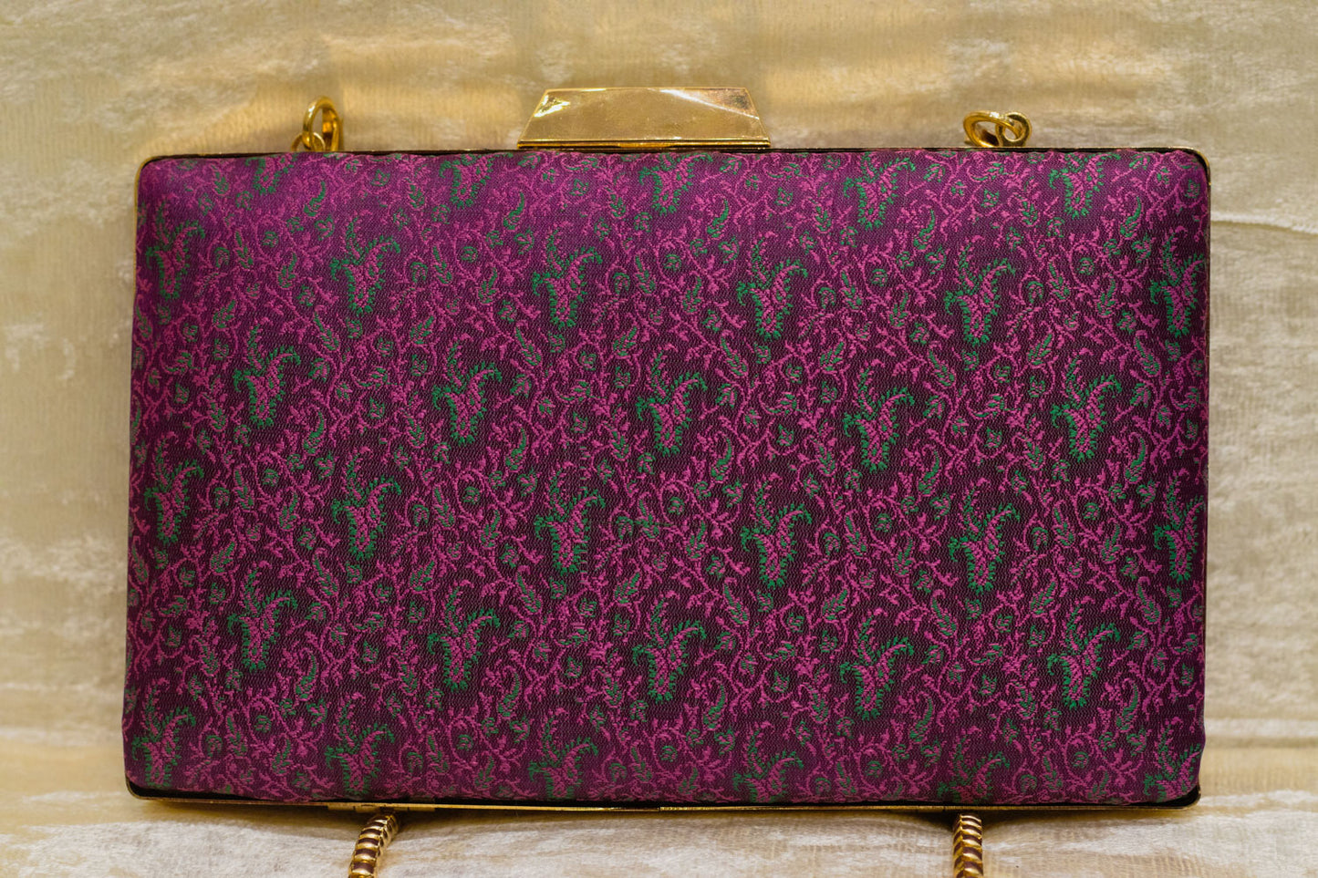 Burgundy Banarasi brocade clutch bag with traditional paisley pattern and gold chain, handmade design.