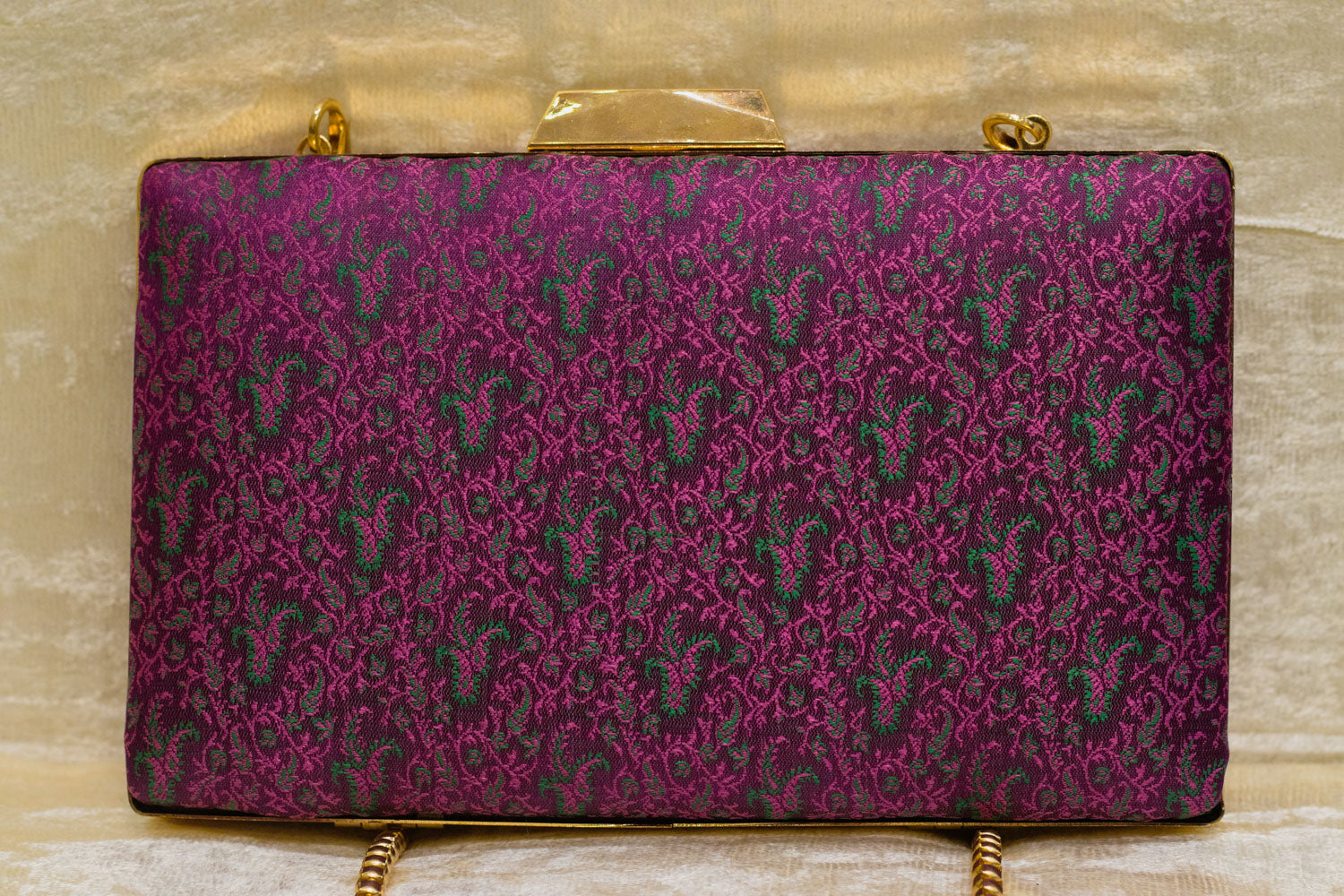 Burgundy Banarasi brocade clutch bag with traditional paisley pattern and gold chain, handmade design.