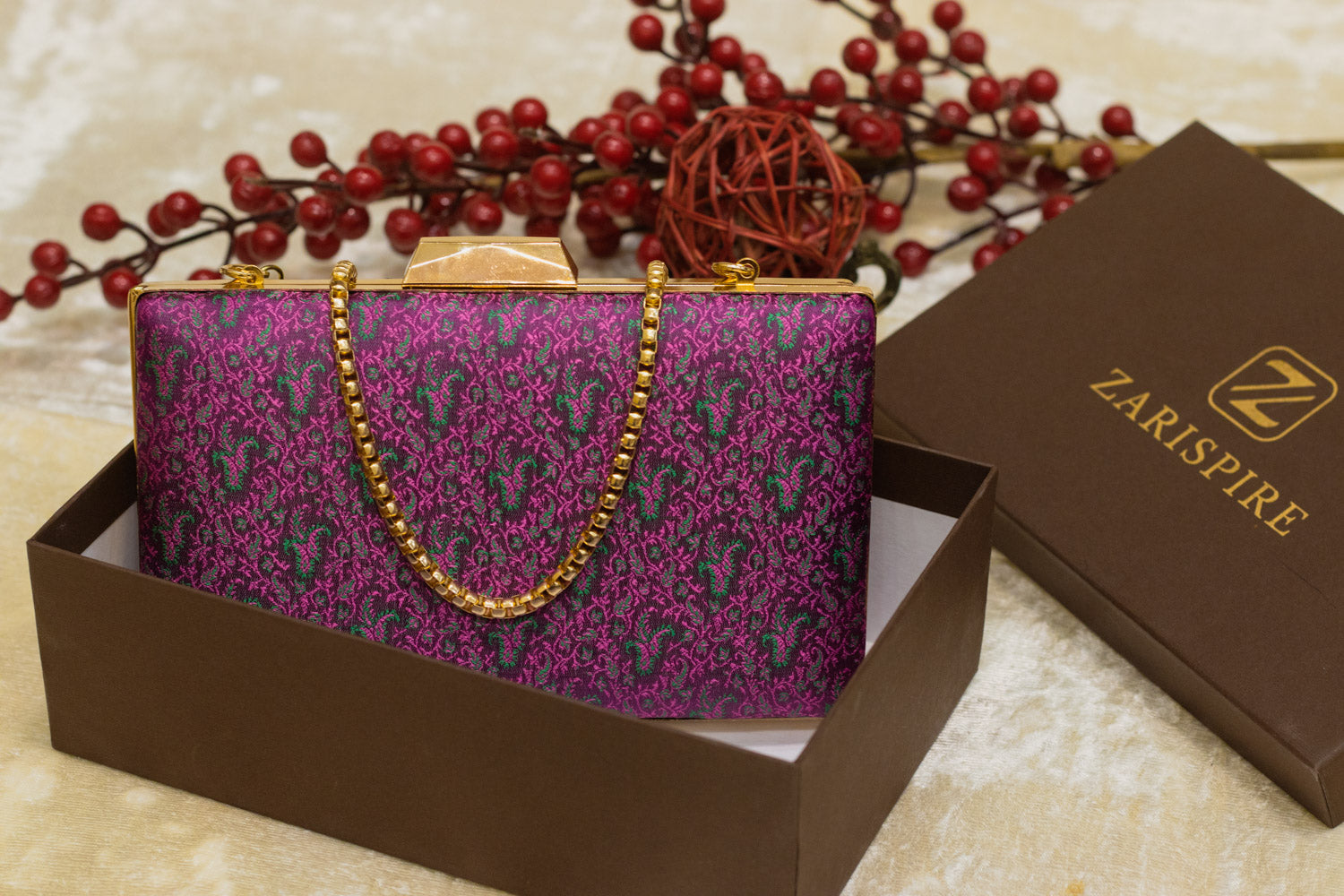Burgundy traditional Banarasi brocade clutch bag with gold chain, handmade sleek design.