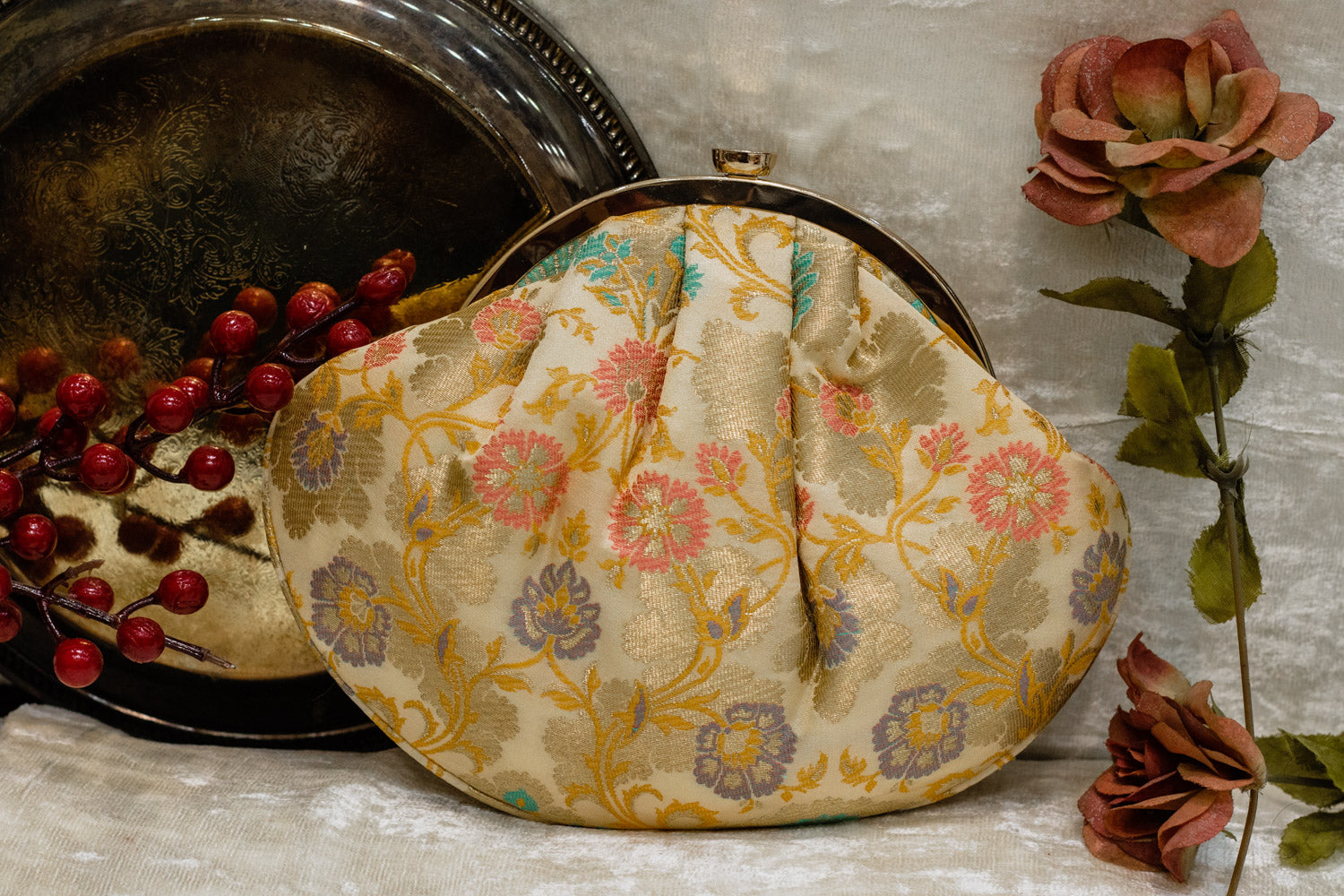 Cream Banarasi brocade clutch bag with traditional floral motifs, handmade with a rounded frame clasp closure.