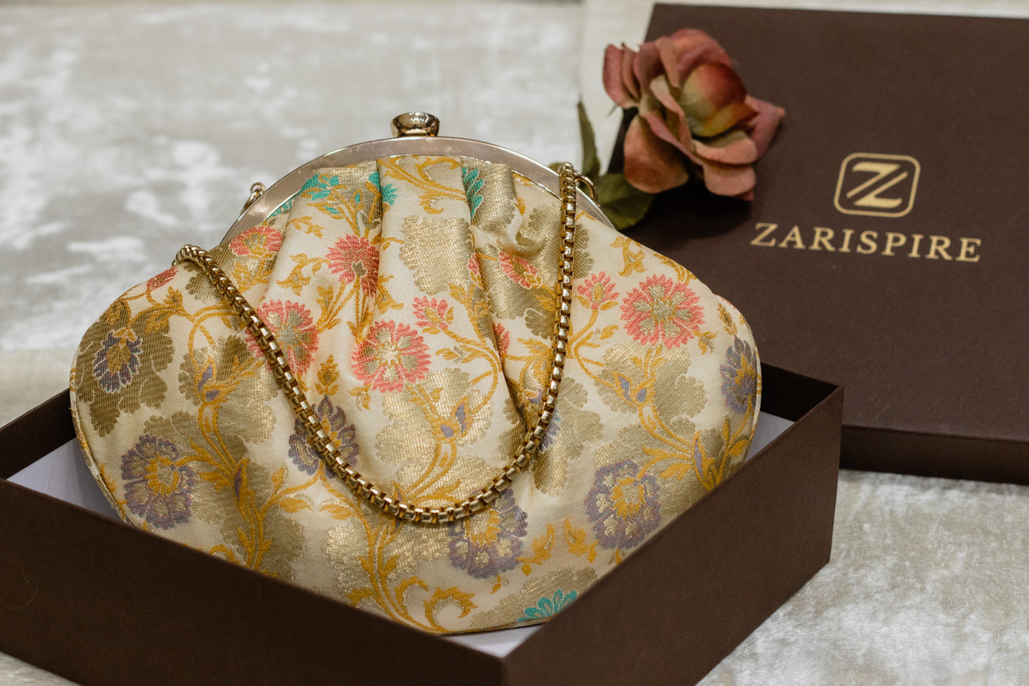 Cream Banarasi brocade clutch bag with floral motifs and gold chain, traditional handmade clutches.