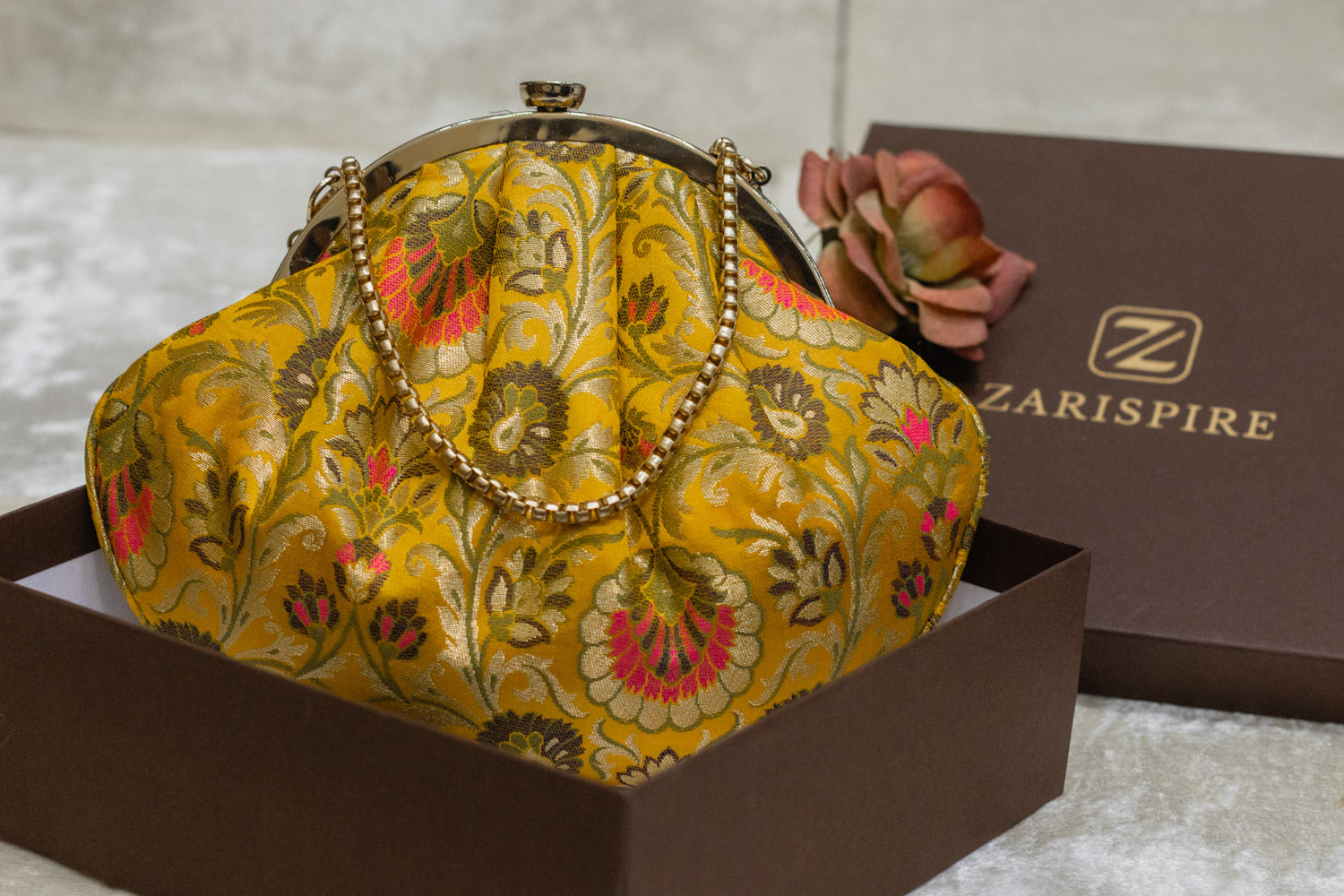 Yellow Banarasi brocade clutch bag with floral embroidery, traditional handmade design, gold chain handle.