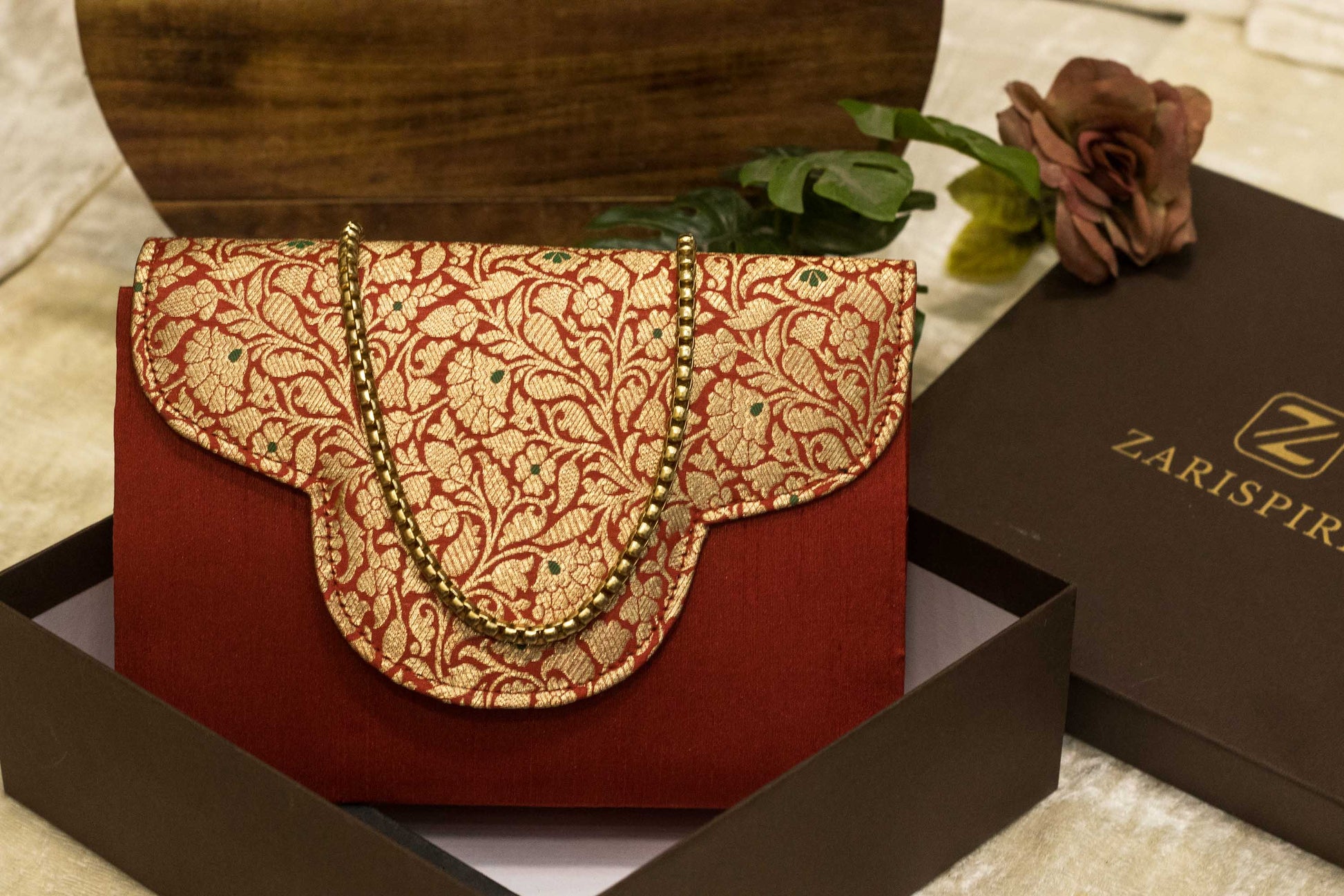 Red Banarasi brocade clutch bag with intricate gold traditional embroidery and scalloped flap, handmade design.